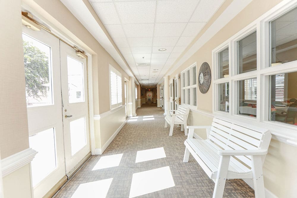 Bright and welcoming hallway with benches at Charter Senior Living in Williamsburg, Virginia