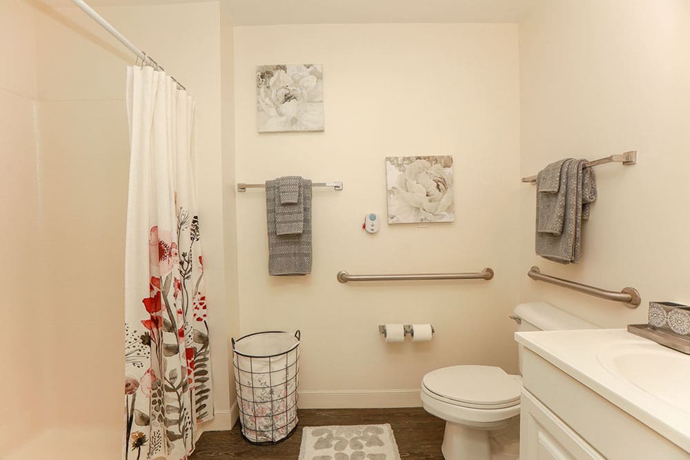 Spacious private senior bathroom with safety grab bars at Charter Senior Living in Williamsburg, Virginia